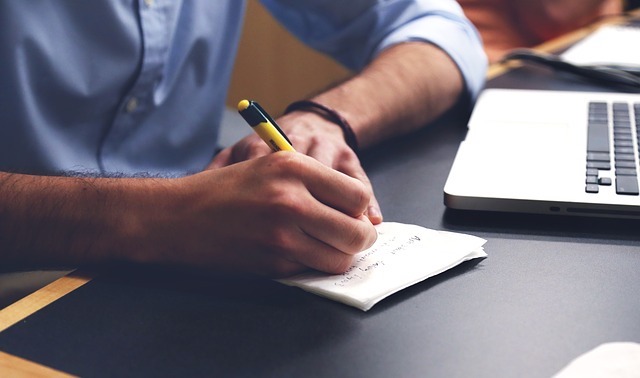 man writing in a notebook