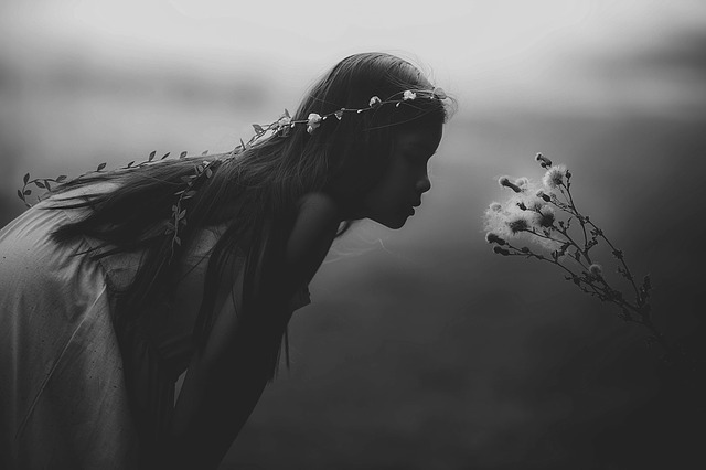 girl blowing a thistle bloom